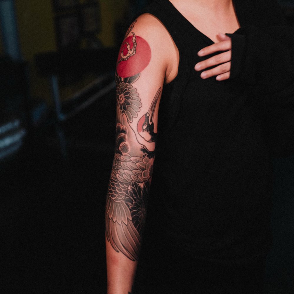Crane & red sun tattoo by Ash Barroga